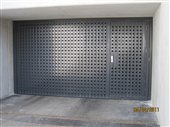 Porta basculante con porta pedonale ventilata